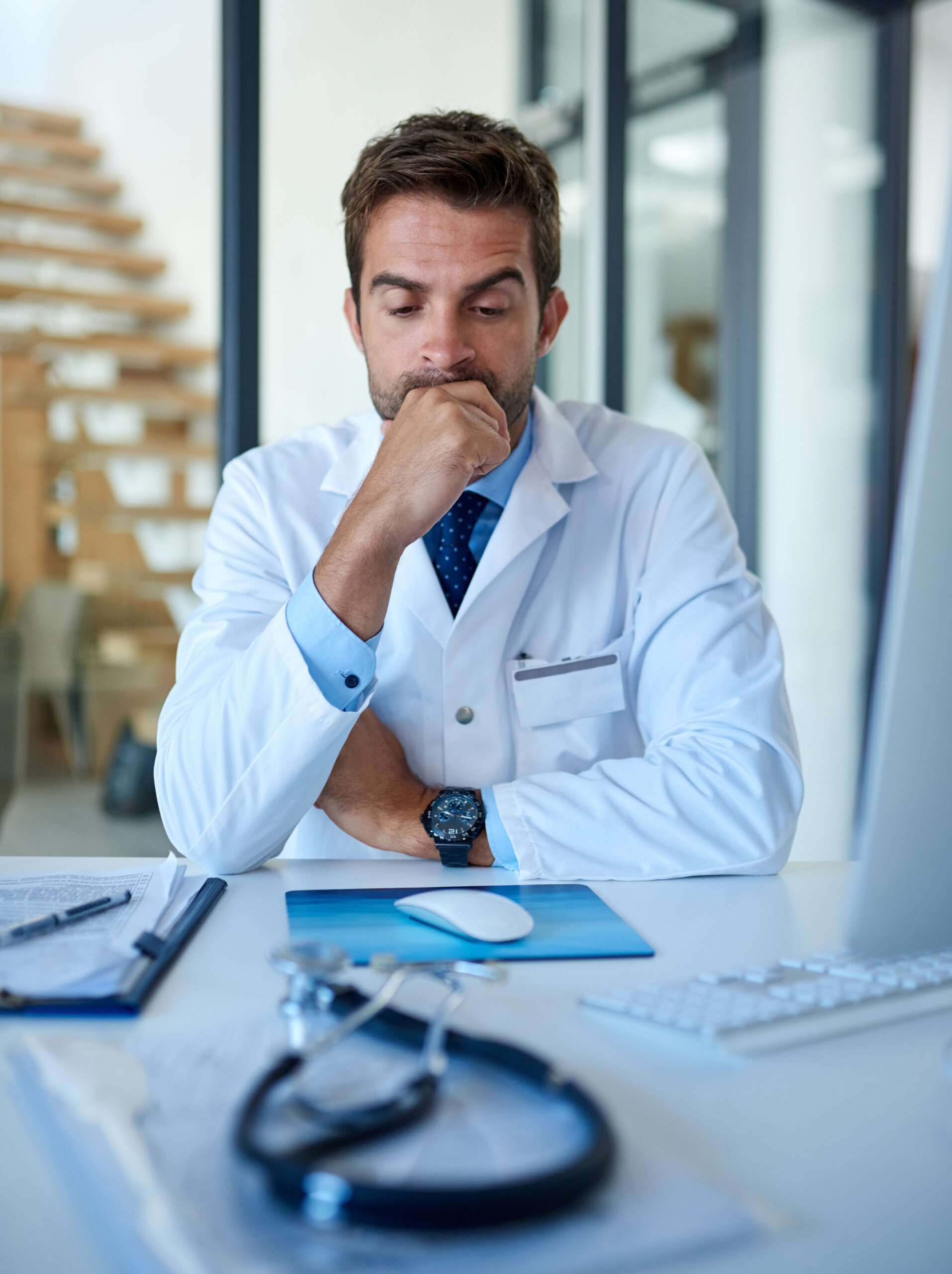 Hospital, thinking and doctor with worry, stress and anxiety for medical career, job and consulting. Professional, healthcare and person with fatigue for overworked, burnout and frustrated in clinic marketing for medical professionals